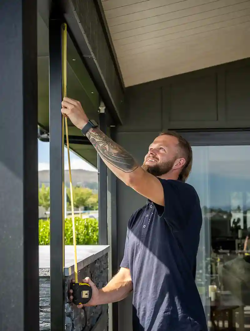 Team member measures and installs blinds